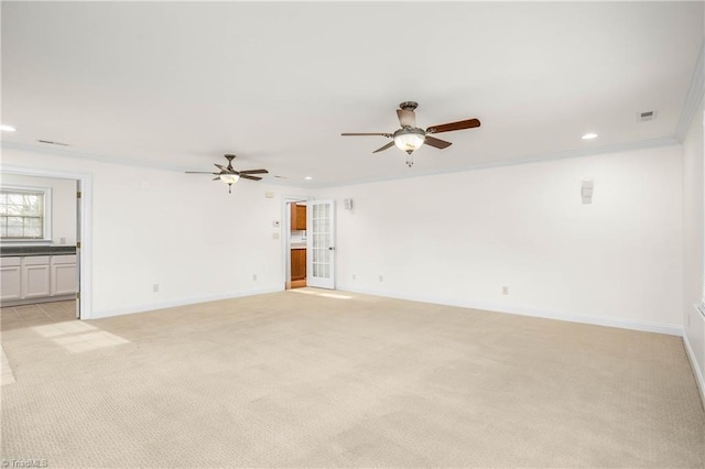 empty room with light colored carpet, baseboards, crown molding, and a ceiling fan