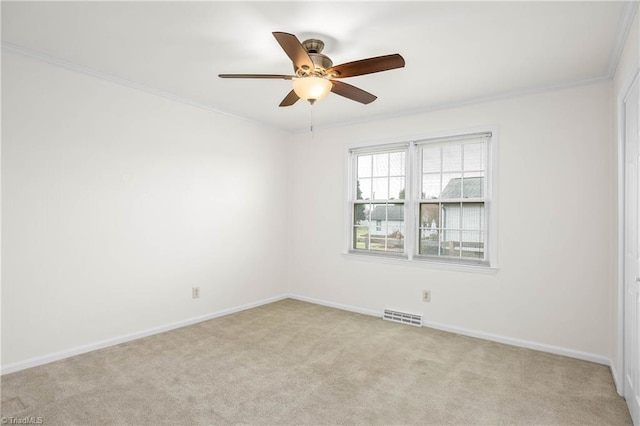 spare room featuring visible vents, crown molding, baseboards, ceiling fan, and light carpet