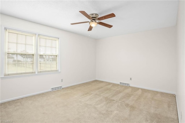 carpeted empty room featuring visible vents, baseboards, and a ceiling fan