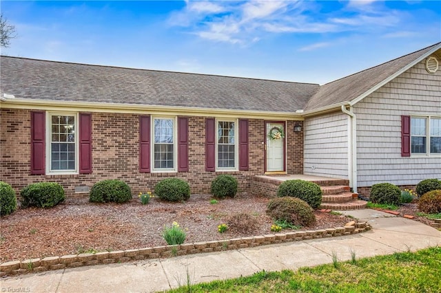 single story home featuring brick siding and roof with shingles