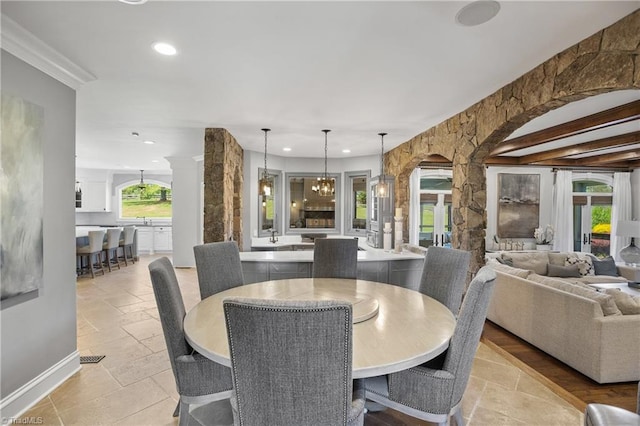 tiled dining space with beamed ceiling and an inviting chandelier