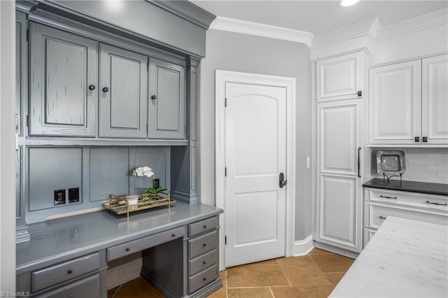 kitchen featuring backsplash, light tile floors, gray cabinetry, and crown molding