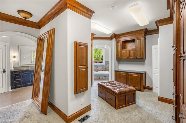 hall featuring crown molding and light tile floors