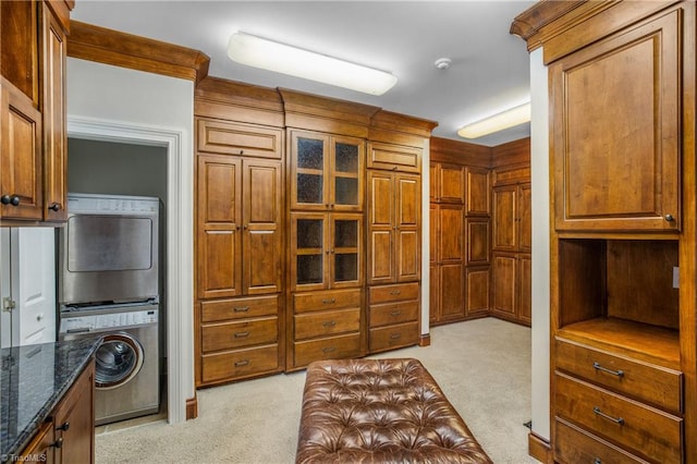 spacious closet with light colored carpet and stacked washing maching and dryer