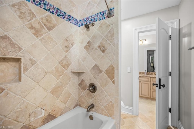 full bathroom with tiled shower / bath combo, tile flooring, vanity, and toilet