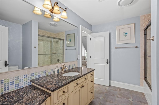 full bathroom with vanity, backsplash, tile flooring, combined bath / shower with glass door, and toilet