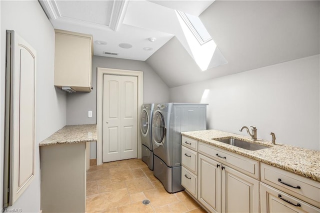 laundry room with a skylight, independent washer and dryer, light tile floors, and sink