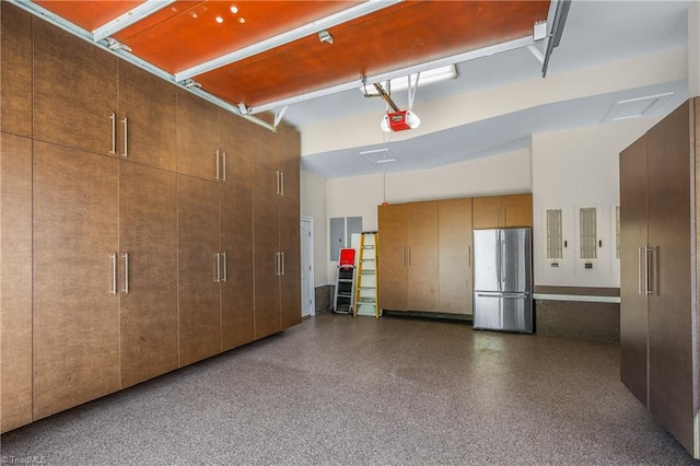 garage with stainless steel fridge and a garage door opener