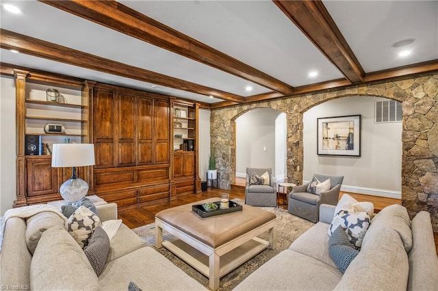 living room featuring beam ceiling, light hardwood / wood-style floors, and built in shelves