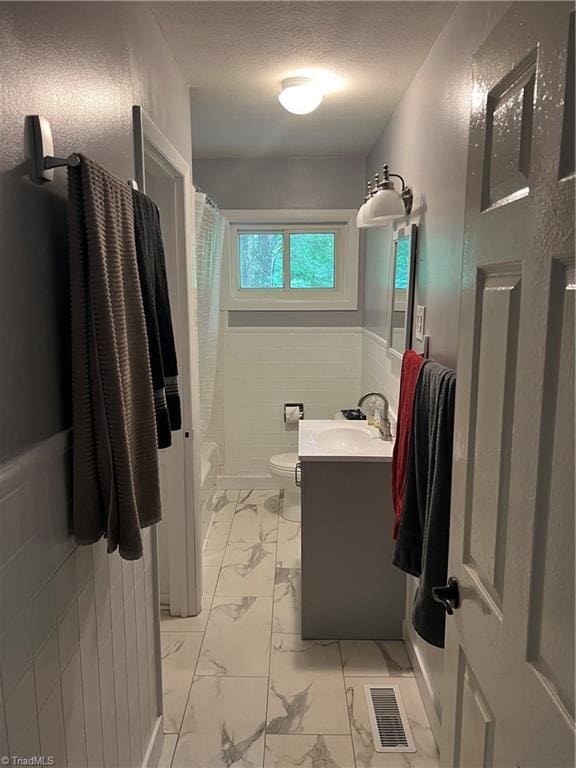 240 Byerly St, Mount Airy, NC 27030 - bathroom featuring marble look tile flooring, vanity, toilet, a wainscoted wall, and a textured ceiling