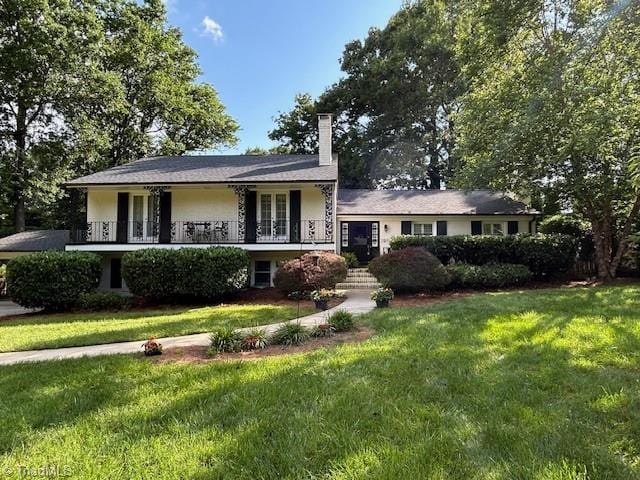 3913 Madison Ave, Greensboro, NC 27410 - tri-level home featuring a front yard and a chimney