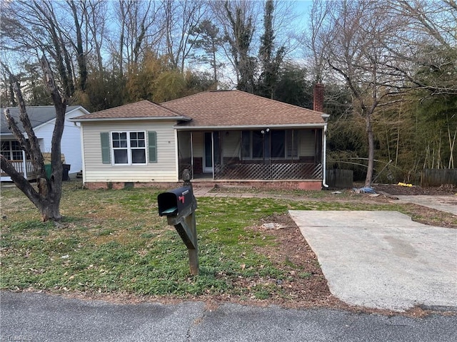 view of front of property featuring a chimney, roof with shingles, crawl space, covered porch, and a front yard