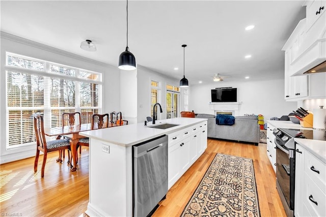 kitchen featuring white cabinetry, appliances with stainless steel finishes, sink, and a center island with sink