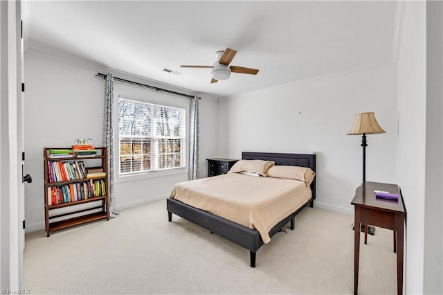 carpeted bedroom with ornamental molding and ceiling fan