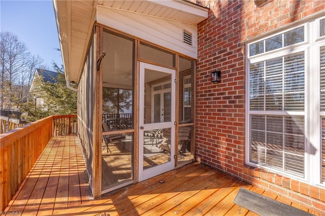 wooden deck with a sunroom