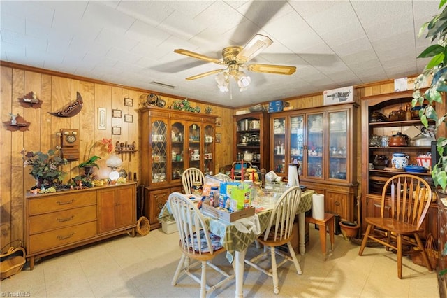 dining room with wooden walls and ceiling fan