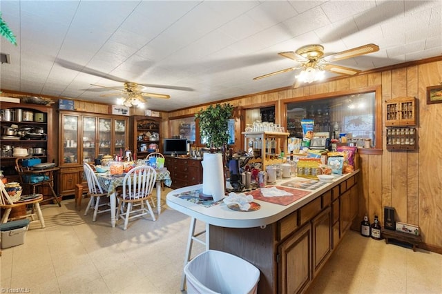 kitchen featuring wooden walls, kitchen peninsula, and ceiling fan