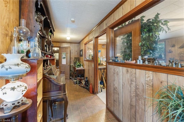 bar featuring ornamental molding, wood walls, and a wealth of natural light