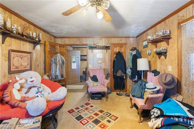 interior space with wooden walls, light carpet, crown molding, and ceiling fan