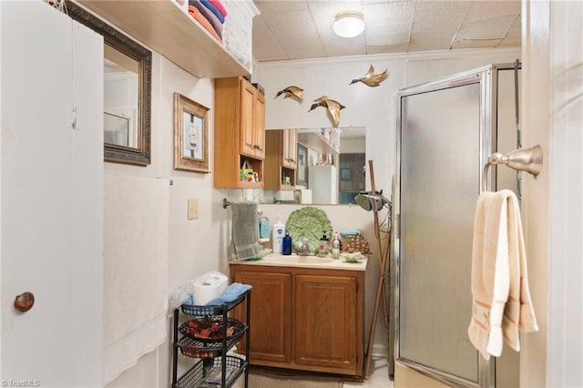 bathroom featuring vanity, crown molding, and an enclosed shower