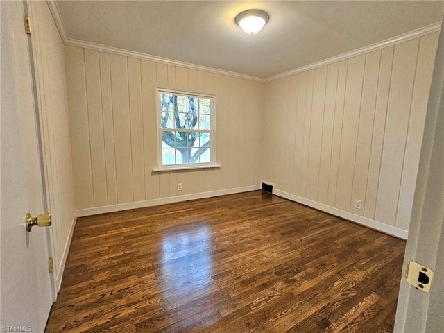 unfurnished room featuring crown molding, wood walls, and dark hardwood / wood-style flooring