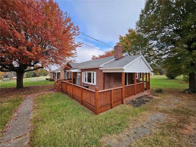 exterior space featuring a front yard and a wooden deck