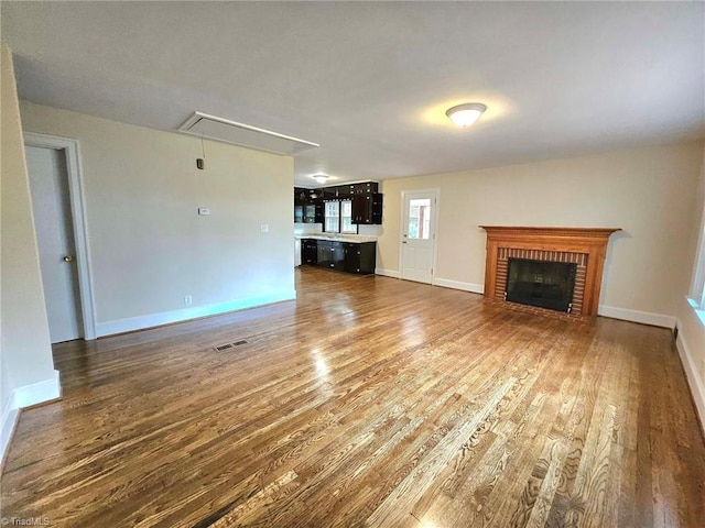 unfurnished living room with dark hardwood / wood-style flooring and a fireplace