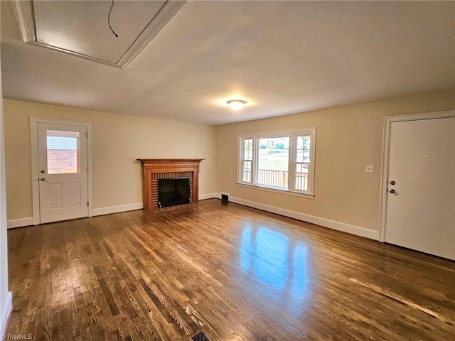 unfurnished living room featuring a wealth of natural light, a fireplace, and dark hardwood / wood-style floors