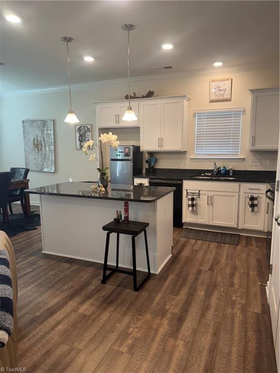 kitchen with sink, decorative light fixtures, white cabinets, a center island, and stainless steel refrigerator