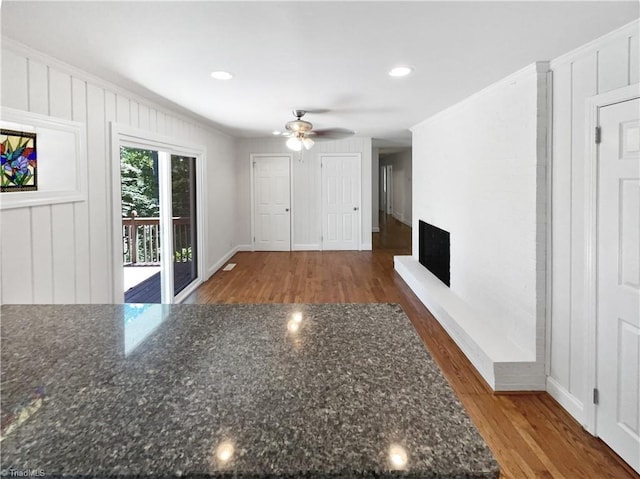 3230 High Cliffs Rd, Pfafftown, NC 27040 - unfurnished living room with ceiling fan, wood finished floors, a fireplace with raised hearth, recessed lighting, and crown molding