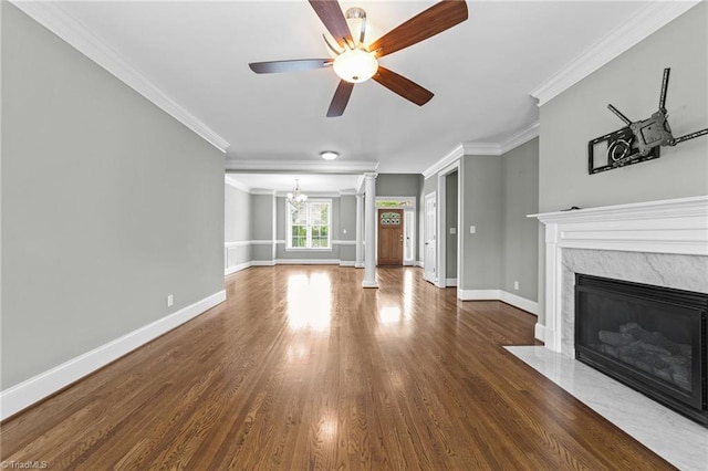 unfurnished living room with crown molding, dark hardwood / wood-style flooring, ceiling fan with notable chandelier, and a fireplace