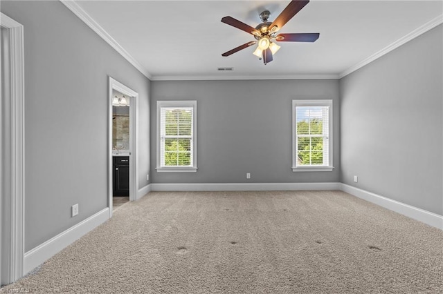 carpeted spare room with crown molding, ceiling fan, and a healthy amount of sunlight