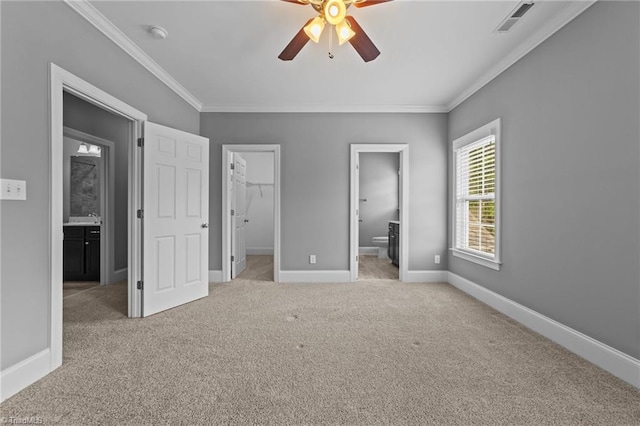 unfurnished bedroom with ceiling fan, connected bathroom, ornamental molding, light carpet, and a spacious closet