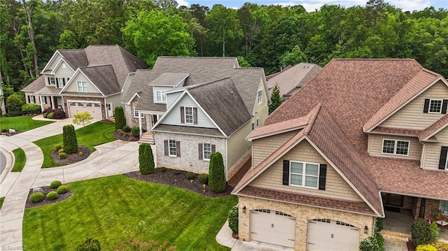 craftsman inspired home with a garage and a front lawn