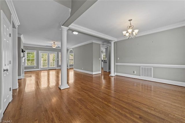 unfurnished living room with hardwood / wood-style floors, crown molding, ceiling fan with notable chandelier, and ornate columns