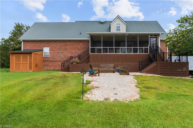 back of house featuring a lawn, a sunroom, and a shed