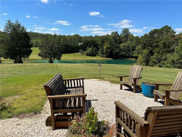 surrounding community featuring a lawn, a patio, and a water view