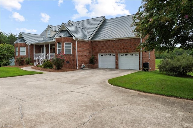 view of front of house with a porch, a garage, and a front lawn