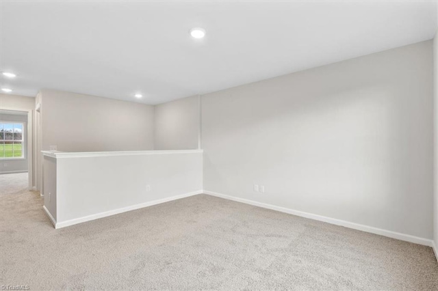 unfurnished room featuring light carpet