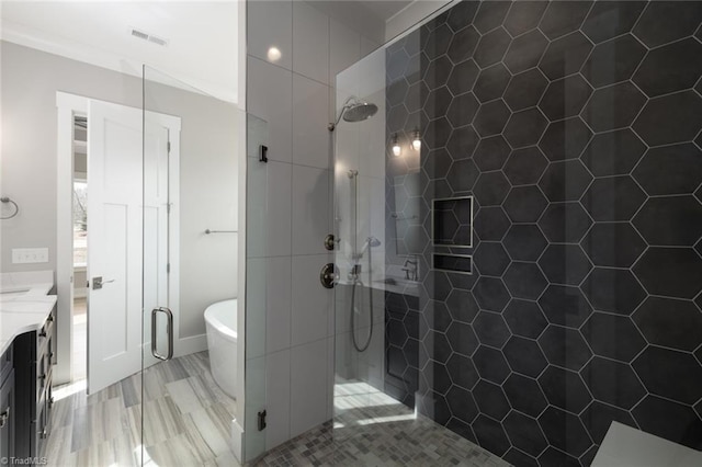 bathroom featuring wood finished floors, a freestanding bath, a stall shower, and vanity