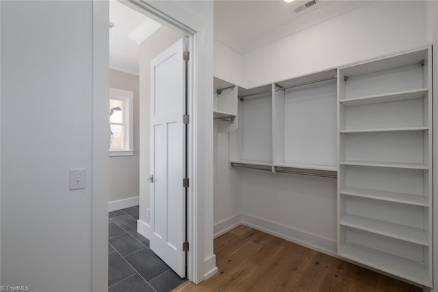 spacious closet featuring dark wood finished floors and visible vents