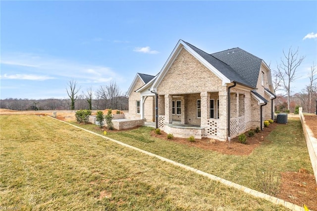 view of side of home featuring brick siding, a patio area, cooling unit, and a yard