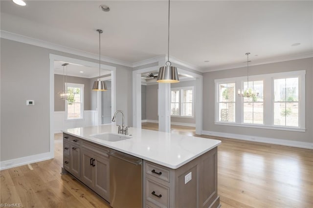 kitchen with light wood-style flooring, a sink, light countertops, stainless steel dishwasher, and a chandelier