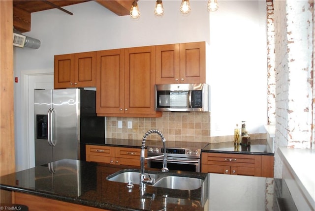 kitchen featuring dark stone counters, brown cabinets, a sink, stainless steel appliances, and backsplash