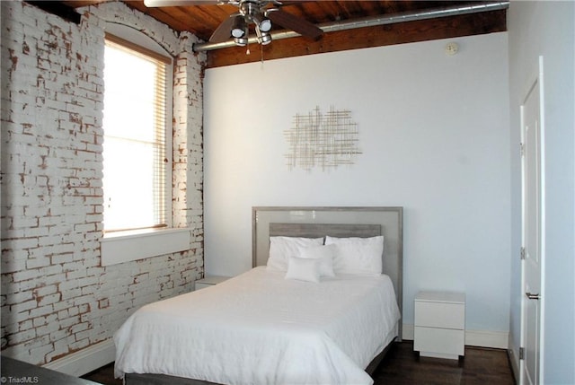 bedroom featuring wood ceiling, baseboards, brick wall, and wood finished floors