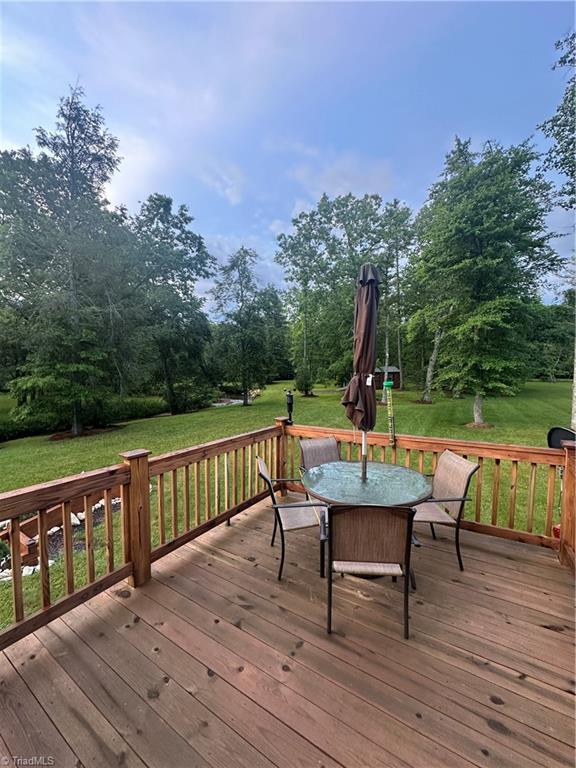 45 Wedgewood Ridge Ln, Fancy Gap, VA 24328 - deck with outdoor dining area, a yard, and view of scattered trees