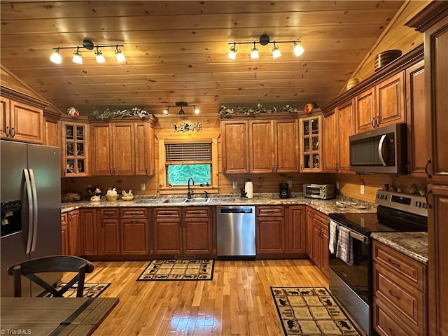 45 Wedgewood Ridge Ln, Fancy Gap, VA 24328 - kitchen with stainless steel appliances, rail lighting, a sink, vaulted ceiling, and brown cabinetry