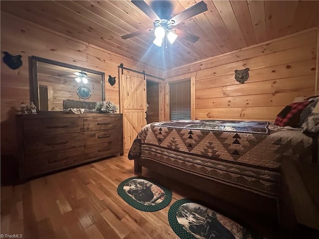45 Wedgewood Ridge Ln, Fancy Gap, VA 24328 - bedroom featuring wood walls, wood finished floors, a barn door, wood ceiling, and ceiling fan