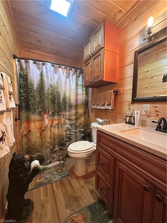 45 Wedgewood Ridge Ln, Fancy Gap, VA 24328 - full bathroom featuring wood finished floors, vanity, wooden walls, toilet, and wood ceiling