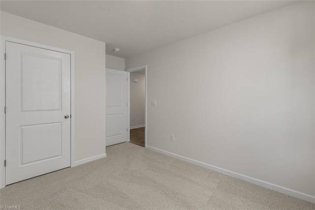 unfurnished bedroom featuring light carpet